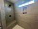 Close-up of tiled shower with dual shower heads and bench seating at 107 Willow Cameron Way, Angier, NC 27501