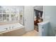 Bright bathroom with a soaking tub and a doorway leading to the Primary bedroom at 11213 Presidio Dr, Raleigh, NC 27617