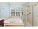 Bright bathroom with a soaking tub under the window and a glass enclosed shower at 11213 Presidio Dr, Raleigh, NC 27617