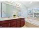 Elegant bathroom with a double sink vanity, a luxurious bathtub, and neutral tile accents at 11213 Presidio Dr, Raleigh, NC 27617