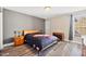 Cozy bedroom with a modern bed frame, bedside tables, and natural light from the window with wood flooring at 11213 Presidio Dr, Raleigh, NC 27617