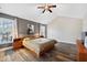 Bright primary bedroom with a ceiling fan, natural light, and ample space with wood flooring at 11213 Presidio Dr, Raleigh, NC 27617