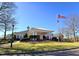 Stately clubhouse entrance with covered portico, American flag, and manicured lawn at 11213 Presidio Dr, Raleigh, NC 27617