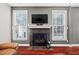Inviting living room featuring a cozy fireplace, television, and bright windows at 11213 Presidio Dr, Raleigh, NC 27617