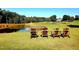 Scenic golf course view featuring Adirondack chairs by a pond and lush greenery at 11213 Presidio Dr, Raleigh, NC 27617