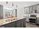 Bright kitchen featuring a large island, gray cabinets, stainless steel appliances, and tiled backsplash at 11213 Presidio Dr, Raleigh, NC 27617