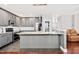 Open-concept kitchen with a granite island, stainless steel appliances, and grey cabinets at 11213 Presidio Dr, Raleigh, NC 27617