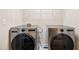 Modern laundry room equipped with two large-capacity front-load washing machines at 11213 Presidio Dr, Raleigh, NC 27617