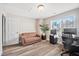 Inviting home office with a comfortable sofa, stylish desk setup, and natural light from the window with wood flooring at 11213 Presidio Dr, Raleigh, NC 27617
