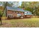 Brick two-story house backyard with a well-manicured lawn and trees at 11705 Appaloosa E, Raleigh, NC 27613