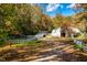 Rustic barn with white fence along a tree-lined driveway at 11705 Appaloosa E, Raleigh, NC 27613