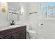 Modern bathroom with dark vanity, marble countertops, and shower with a black-framed glass door at 11705 Appaloosa E, Raleigh, NC 27613