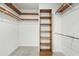 Spacious walk-in closet featuring wooden shelves, white walls and gray carpet at 11705 Appaloosa E, Raleigh, NC 27613