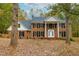 Stately brick home featuring a columned entrance and mature trees in a lush, leafy front yard at 11705 Appaloosa E, Raleigh, NC 27613