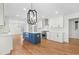Modern kitchen with white cabinets, stainless steel appliances, a blue island, and hardwood floors at 11705 Appaloosa E, Raleigh, NC 27613