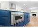 Kitchen island boasts built-in microwave, ample storage with navy cabinets, and hardwood floors at 11705 Appaloosa E, Raleigh, NC 27613