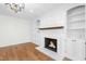 Cozy living room featuring a fireplace with built-in shelves, and gleaming hardwood floors at 11705 Appaloosa E, Raleigh, NC 27613