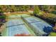 Aerial view of the tennis and basketball courts surrounded by mature trees at 11705 Appaloosa E, Raleigh, NC 27613