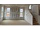 Spacious living room with large windows, staircase and unfinished drywall, perfect for customization at 135 Cameron Willow Way Way, Angier, NC 27501