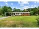 Charming single-story home featuring a brick facade and a spacious front lawn under a bright, cloudy sky at 135 Rainbow Dr, Dunn, NC 28334