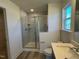 Modern bathroom features a glass-enclosed shower with marble tile and a bright window at 135 Willow Cameron Way, Angier, NC 27501
