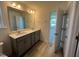 Bathroom featuring double sink vanity with gray cabinets and a large mirror at 135 Willow Cameron Way, Angier, NC 27501