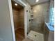 Walk-in shower with sleek fixtures and tile, plus a peek into a walk-in closet, showcasing modern design at 136 Willow Cameron Way, Angier, NC 27501