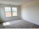 Bright, carpeted bedroom featuring a window providing natural light at 136 Willow Cameron Way, Angier, NC 27501