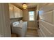 Well-lit laundry room equipped with modern washer and dryer, plus shelving for all your cleaning needs at 136 Willow Cameron Way, Angier, NC 27501