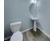 Powder room featuring a pedestal sink, oval mirror, and wood-look floors at 151 N Great White Way, Clayton, NC 27527