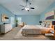 Beautiful staged bedroom with light blue walls, a ceiling fan, and neutral toned furniture at 151 N Great White Way, Clayton, NC 27527