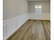 Bright dining room with wood-look floors, white wainscoting, and elegant chandelier at 151 N Great White Way, Clayton, NC 27527