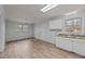 Functional kitchen area with natural light, laminate floors, white cabinets and double sink at 1721 Fountain St, Rocky Mount, NC 27801