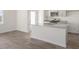 Bright kitchen features a granite island, stainless appliances, white cabinets and wood flooring at 212 Starlight St, Sanford, NC 27330