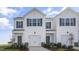 Charming townhome featuring a two-car garage, black shutters, and stone accents at 220 Starlight St, Sanford, NC 27330