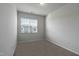 Bedroom featuring neutral carpet, white walls, and a large window at 227 Liam St, Clayton, NC 27520