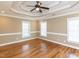 Bedroom featuring hardwood floors, tray ceiling with fan, recessed lights and natural light from three windows at 2420 New Bethel Church Rd, Garner, NC 27529