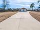 Long concrete driveway leading to a well-maintained brick home, enhancing curb appeal at 2420 New Bethel Church Rd, Garner, NC 27529