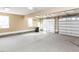 Spacious three-car garage featuring a concrete floor, white doors, and natural light at 2420 New Bethel Church Rd, Garner, NC 27529