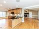 Bright kitchen featuring wood cabinets, granite counters, kitchen island, hardwood floors and stone fireplace at 2420 New Bethel Church Rd, Garner, NC 27529