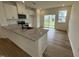 Modern kitchen with a large island, granite countertops, stainless steel appliances, and access to the backyard at 2644 Pivot Ridge Dr, Raleigh, NC 27616