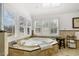 Bright bathroom with a soaking tub next to shuttered windows and travertine tile surround at 2949 Tillinghast Trl, Raleigh, NC 27613