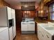 Vintage kitchen featuring wood cabinets, brick accents, white appliances, and double-basin sink at 405 N Wilson Ave, Dunn, NC 28334
