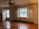 Bright living room featuring hardwood floors, fan, and large window at 405 N Wilson Ave, Dunn, NC 28334