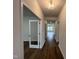 Hallway leading to a living room with hardwood floors, neutral paint, and a view of the backyard at 4404 Emeline Way # 35, Fuquay Varina, NC 27526