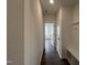 A hallway featuring modern wood flooring, fresh white paint, and a convenient drop zone with built in bench and coat hooks at 4404 Emeline Way # 35, Fuquay Varina, NC 27526