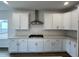 Kitchen features white cabinets, stainless steel appliances, white subway tile backsplash, and hardwood floors at 4404 Emeline Way # 35, Fuquay Varina, NC 27526