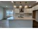 Modern kitchen features a center island with pendant lighting, white cabinets, stainless steel appliances, and hardwood floors at 4404 Emeline Way # 35, Fuquay Varina, NC 27526