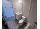 This bathroom features a shower-tub combo, a single vanity, and modern gray laminate floors at 5520 Neuse View Dr, Raleigh, NC 27610