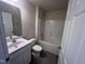 This bathroom features a shower-tub combo, a single vanity, and wood-look laminate floors at 5520 Neuse View Dr, Raleigh, NC 27610